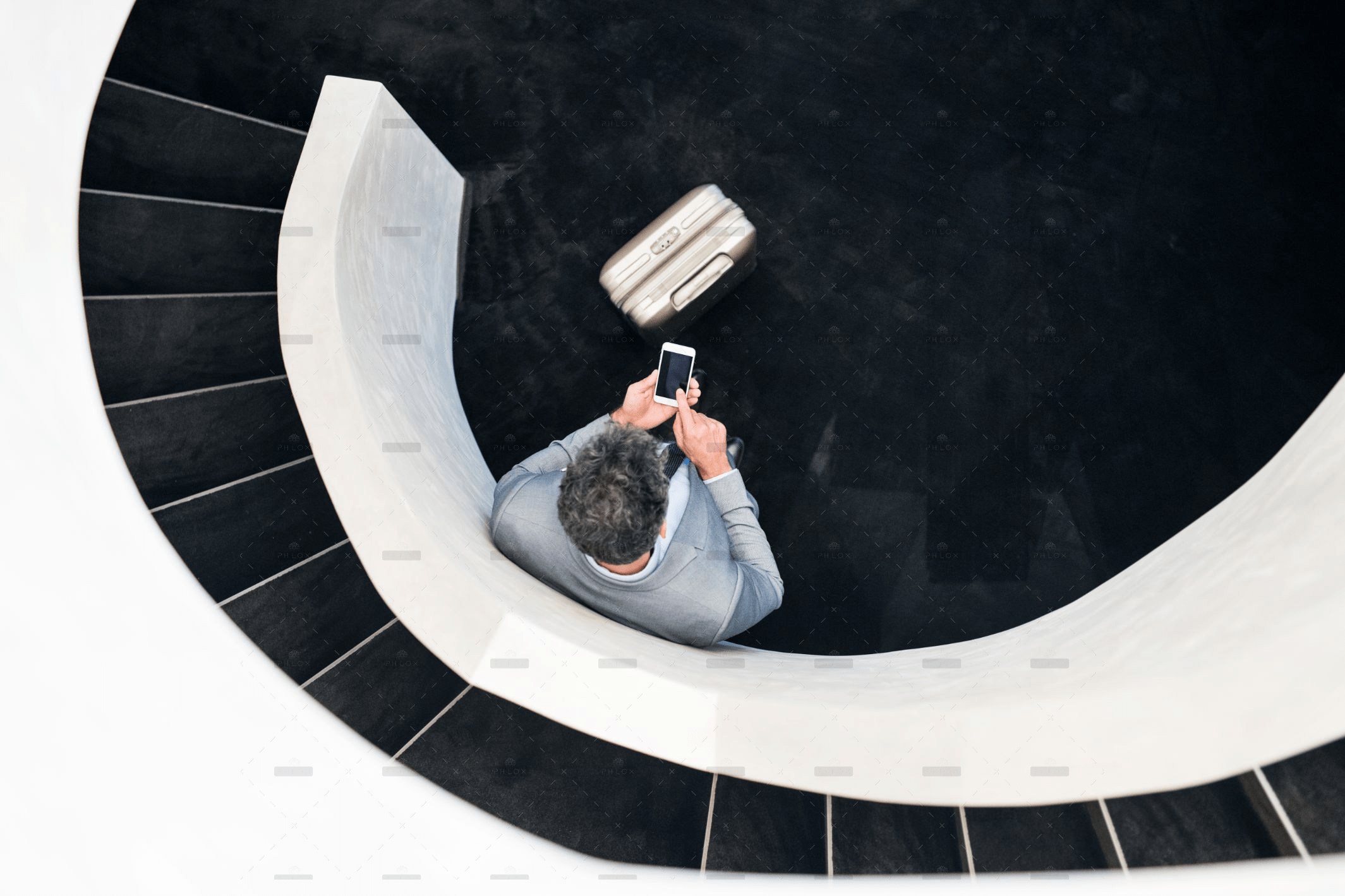 demo-attachment-501-Businessman-with-smartphone-standing-at-staircase.@2x